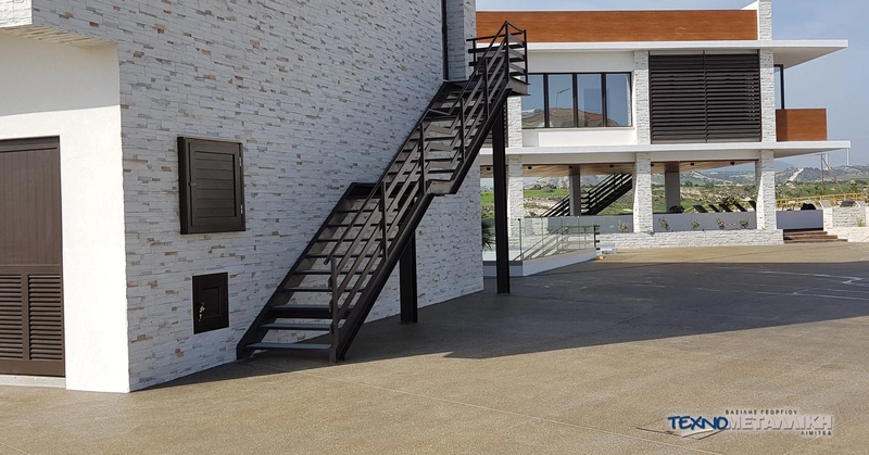 Dark powder-coated outdoor metal staircase installed in Cyprus by Technometalliki Ltd.