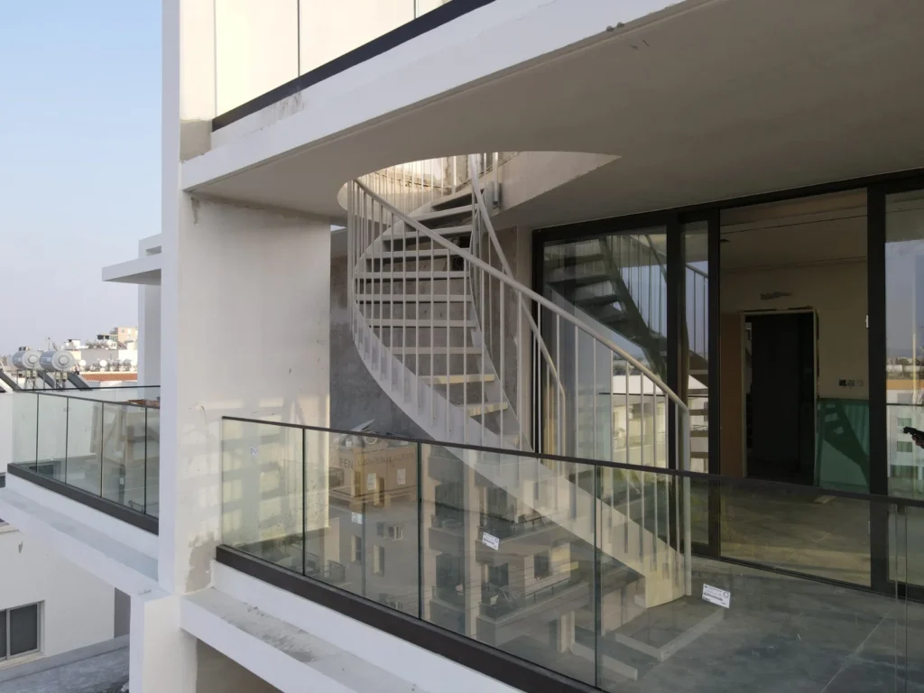 Modern metal spiral staircase on a building balcony in Cyprus, featuring contemporary architectural design by Technometalliki LTD