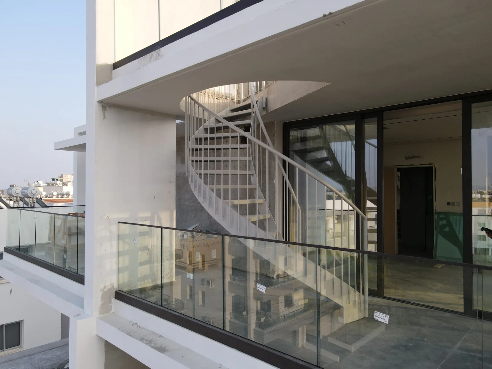 Modern metal spiral staircase on a building balcony in Cyprus, featuring contemporary architectural design by Technometalliki LTD